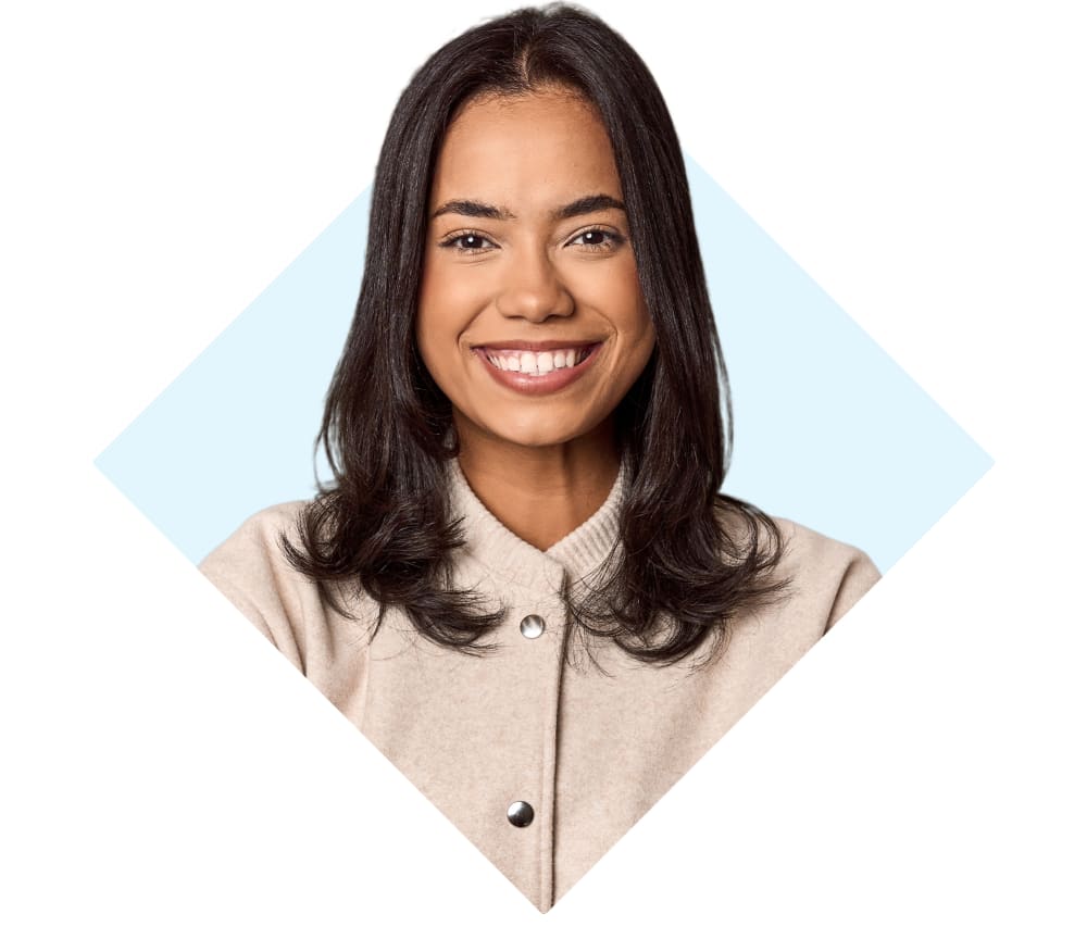 An adult woman is smiling with her arms crossed.